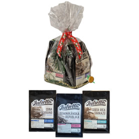 Julietta dárkový balíček Karibik – tři balení zrnkové kávy zabalené v celofánu se stuhou a ozdobnou zelení.